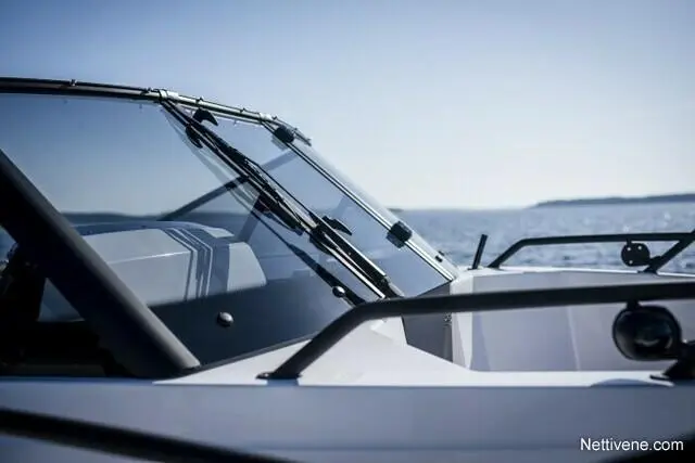 A close-up view of a boat's windshield against a serene ocean backdrop, highlighting sleek design and clear visibility.